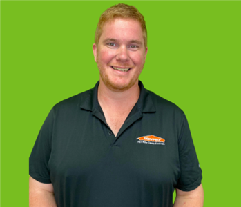 Male Employee with Blonde Hair Smiling On Green Background