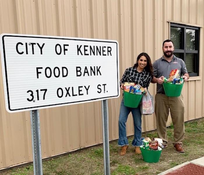 Marketing Reps Shelby Clement and Jake Olivier Dropping off  food in front of Kenner Food Bank
