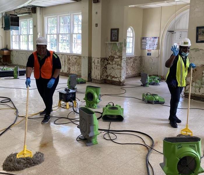 SERVPRO employees cleaning large commercial building after water loss